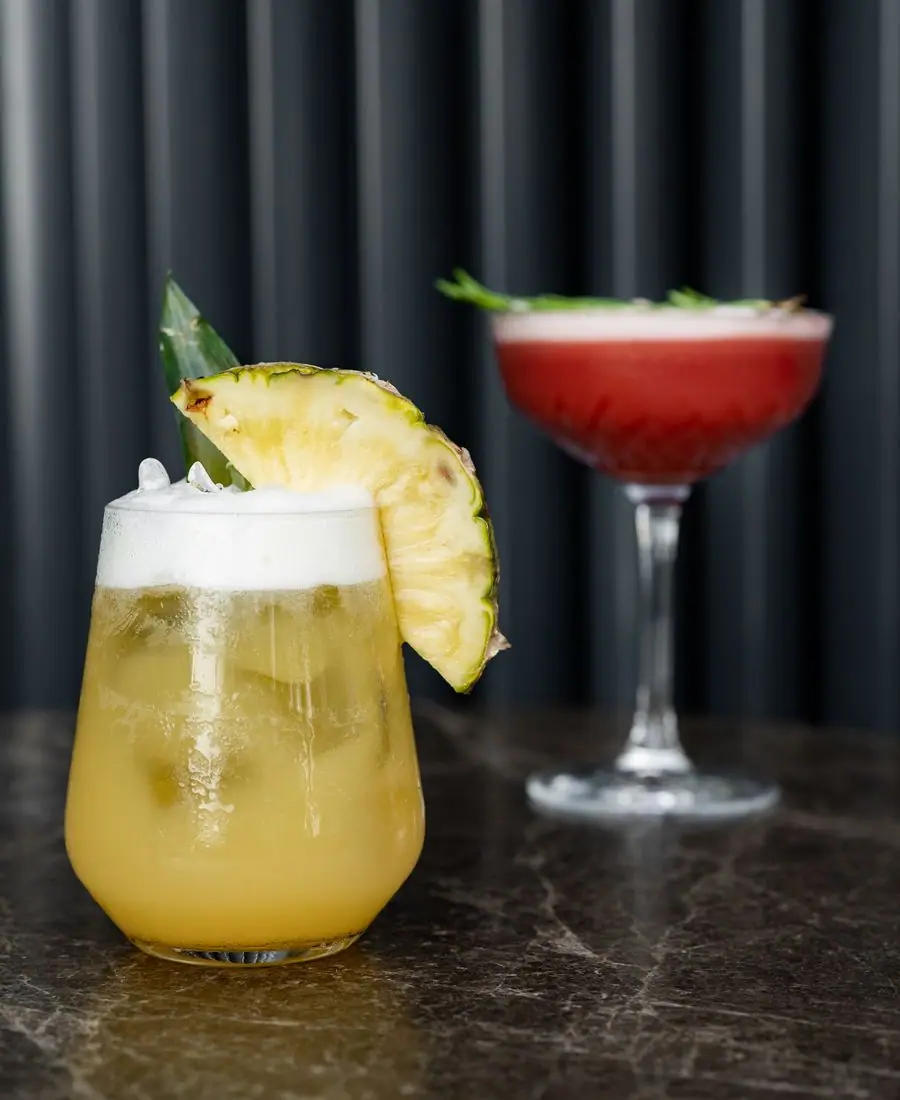 Crystal-clear martini in a chilled coupe glass with a lemon twist set against a dark dramatic background